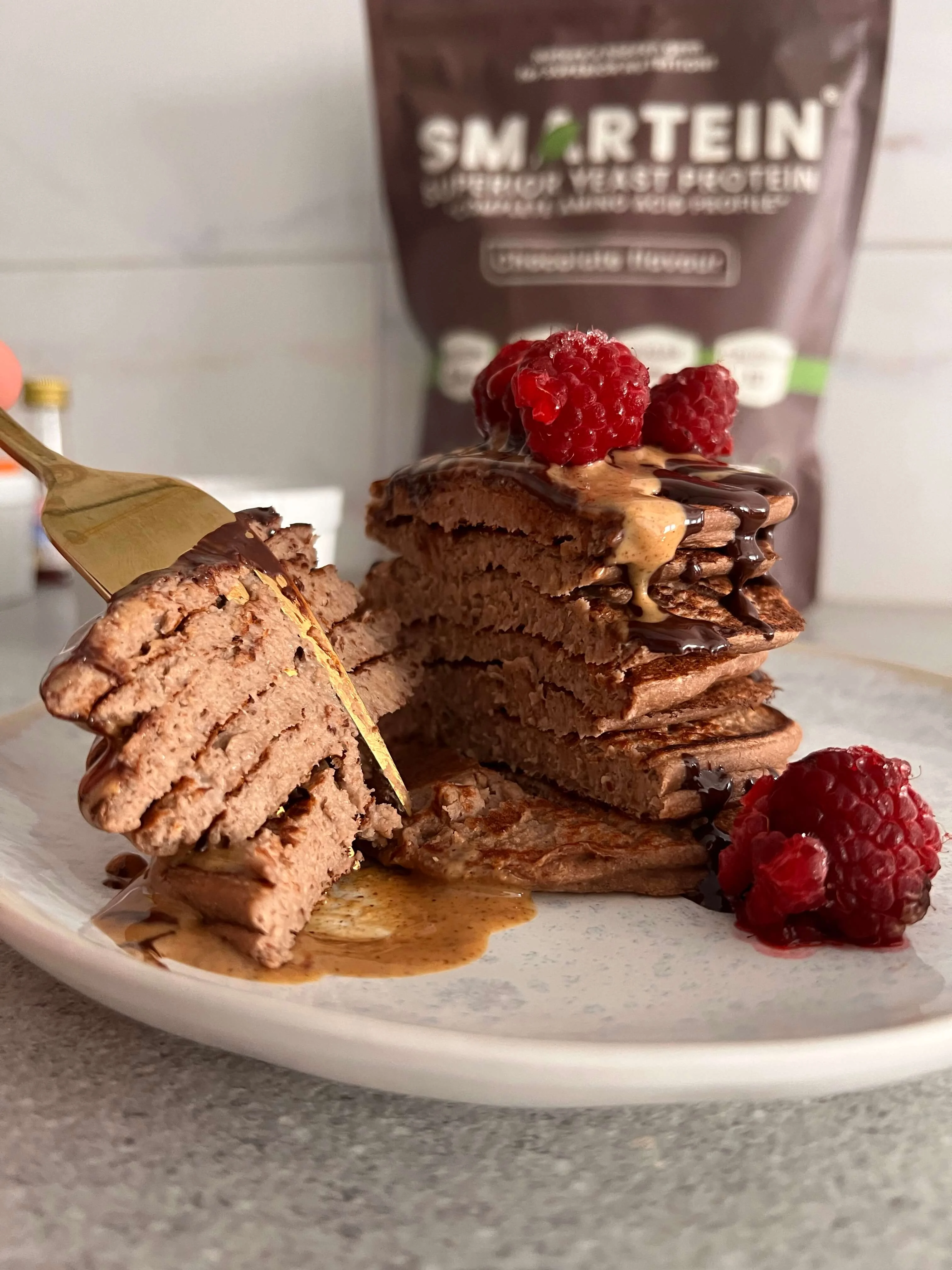 Posne proteinske palačinke prelivene čokoladom i kikiriki puterom sa malinama