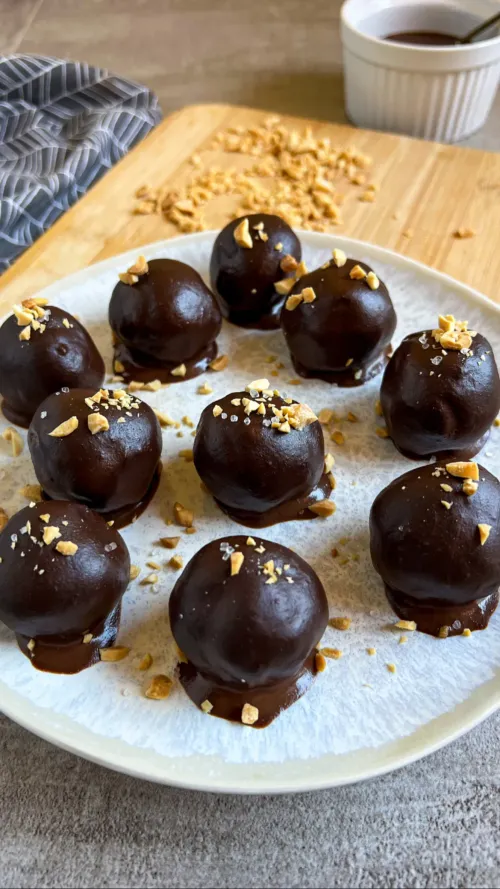 Proteinske kuglice sa kikirikijem prelivene tamnom čokoladom i posute krupnom solju