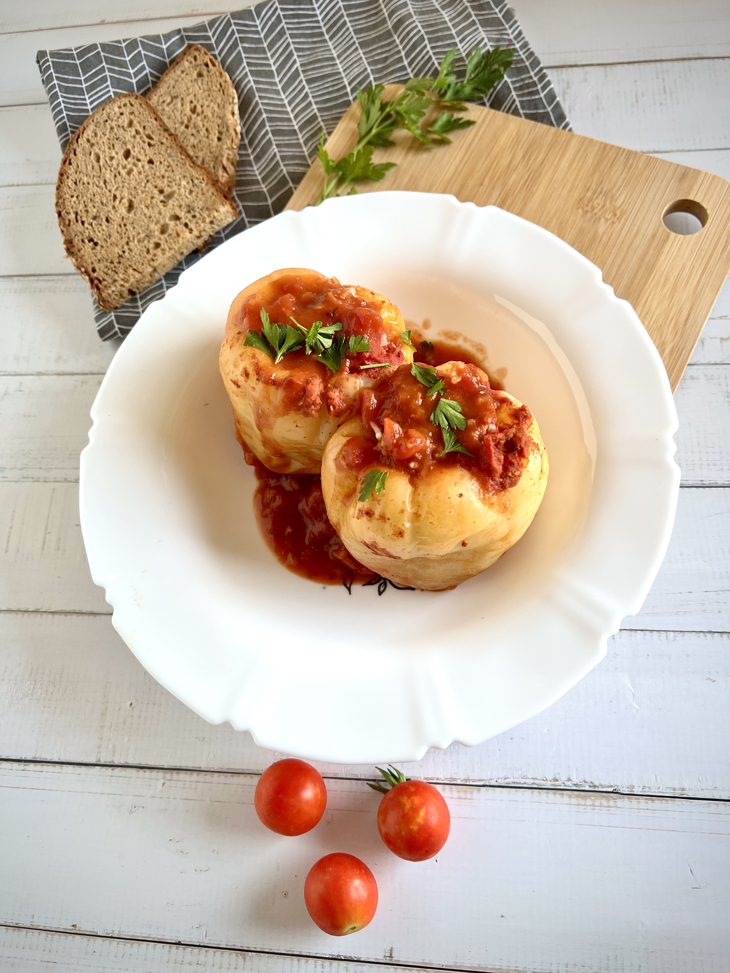 Punjene paprike u paradajz sosu servirane u tanjiru