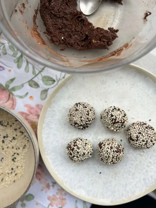 Čokoladne tahini kuglice uvaljane u susam na tanjiru